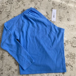 Blå oneshoulder topp från Gina Tricot - Ljusblå oneshoulder topp från Gina Tricot i ribbad bomullsmix. I storlek S. Aldrig använd. 