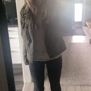 Grön Polo Ralph Lauren jacka - Snygg olivgrön jacka från Polo Ralph Lauren med militärinspirerade detaljer och patch på ärmen. Jackan har två bröstfickor med lock, klassisk krage och knappar vid ärmslut. Perfekt för dig som gillar en clean och cool stil. Kan gå ner i pris🩷🩷