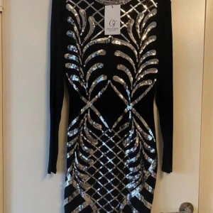 Festklänning - Helt ny och oanvänd festklänning från Chiara Forthi Milano, storlek M Säljer en helt ny och oanvänd festklänning från Chiara Forthi Milano med prislapp kvar (utan pris). Svart färg med silverpaljetter – mycket snygg och elegant. Perfekt för fest och speciella tillfällen. Hög kvalitet och i storlek M. Ett fantastiskt val om du vill sticka ut på festen!