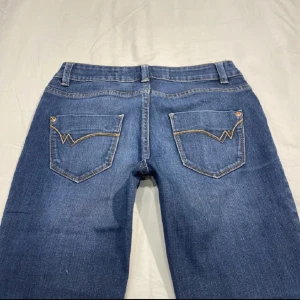 Blå lågmidjade bootcut jeans med broderade fickor - Snygga blå lågmidjade bootcut jeans med coola broderade detaljer på bakfickorna. Jeansen är stretchiga och sitter skönt. Skriv vid frågor😊 Och varsågod att pruta 