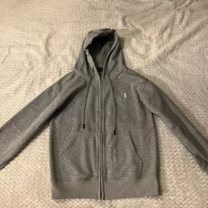 Grå hoodie från Polo Ralph Lauren - Den är oanvänd, skriv till mig om du vill ha mer foton så fixar jag. Tröjan är size S men är liten i storleken. Skriv till mig för mer information så hjälper jag Järna till👍