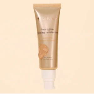 Hickap Honey Glow Priming Moisturizer - Hickap Honey Glow Priming Moisturizer är en primer i beige-guldig tub med pump. Den ger en glowig finish och funkar för alla hudtyper. Innehåller 50 ml och är 100% vegansk. Perfekt för att skapa en jämn bas innan sminket. Tuben är i plast med guldiga detaljer.