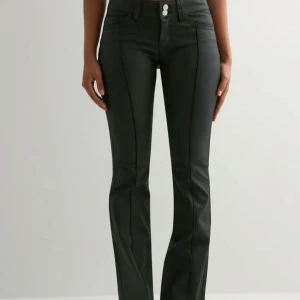 Svarta bootcut byxor från Nelly - Säljer ett par svarta bootcut-byxor från Nelly med låg midja och snygg glansig finish. Super fina och aldrig använda!💕