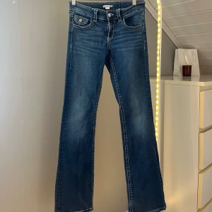 Blå bootcut jeans från Gina Tricot - Mörkblå jeans från Gina young med normal passform, låg midja,vita sömmar och snygga bakfickor. Säljer då dom är förkorta och inte används. Jeansen är använda ett antal gånger men det är inget som syns!