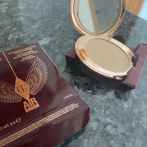 Charlotte Tilbury Airbrush puder - Säljer Charlotte Tilbury Airbrush Flawless Finish, en pressad puder i lyxig roséguldig dosa med spegel. Ger en silkeslen finish och mattar ner huden utan att kännas kakig. Perfekt för att fixera sminket och få en jämnare hudton.
