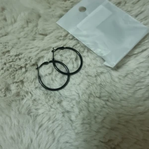 Svarta hoops örhängen 4 cm - Stilrena svarta hoops / creoler. örhängen med rund form, cirka 4 cm i diameter. 316L kirurgiskt stål.  Helt nya, endast uttagna för att ta bilder.