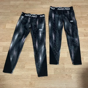 Nike Pro svarta leggings med mönster - Nike Pro leggings i svart med coolt vågigt mönster och bred resår i midjan med logga. Sitter tight och är perfekta för träning. Materialet är stretchigt och andas, vilket gör dem riktigt sköna att ha på sig. De är helt oanvända bara påprovade. Dem är storlek L fast i barn storlek.Kontakta mig om ni bara vill ha ena paret❣️dem kostar 199kr styck, men priset kan diskuteras.