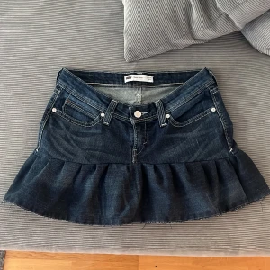 Lågmidjad volangkjol  - Säljer en lågmidjad jeanskjol med volanger som jag sytt själv väldigt noga från skinny jeans, midjemått 39 cm, längd fram 27 cm längd bak 36 cm 💙