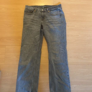 Weekday Arrow Low Straight Jeans 29/30 - Säljer ett par gråa Weekday Arrow Low Straight jeans i klassisk femficksmodell. Jeansen har låg midja och raka ben, med snygga slitningar och vintage vibe. Tillverkade i bomull och perfekta för en avslappnad streetstil.