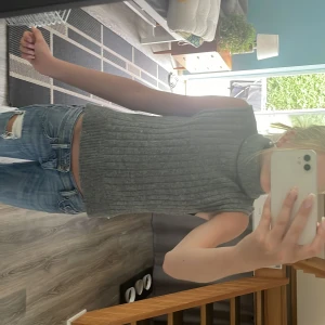 Grå ribbad stickad polotopp - Säljer en grå stickad polotopp med ribbat mönster. Jätte gullig och super skönt material. 