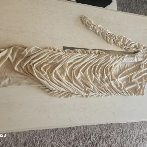 Champagnefärgad one shoulder klänning Shein - Säljer en champagnefärgad kortklänning från Shein i storlek M. Klänningen har one shoulder-design med snygga draperingar och figurnära passform. Perfekt för dig som vill sticka ut med en elegant och trendig look.