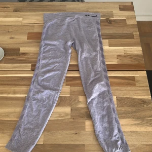 Grå leggings från Hummel - Snygga ljuslila leggings från Hummel med bred midja och diskret logga framtill. De har ribbade detaljer längs sidorna och är tillverkade i mjukt syntetmaterial som sitter tight och bekvämt. Perfekta för träning eller chill hemma. Syrellila. Använda en handfull gånger, max.