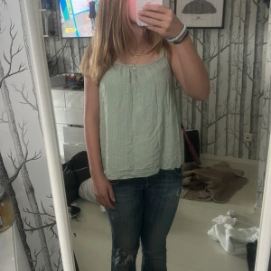 Ljusgrön linnetopp med tunna axelband - Säljer en chill ljusgrön linnetopp med tunna axelband och avslappnad passform. Toppen har en lätt skrynklig struktur och är perfekt för varma dagar. Enkel och stilren design som funkar till jeans eller shorts. Fråga gärna om fler bilder eller mått!