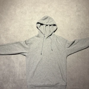 Grå hoodie från Jack and Jones  - Säljer en stilren grå hoodie med huva och snörning. Sparsamt använt och nypris ligger på cirka 400 kronor. Jag är 176 60 kilo Skriv om du har några frågor 