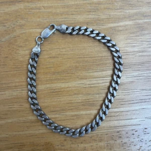 Kedjearmband i silverfärg - Stilrent armband med klassisk kedjelänk i silverfärg. Perfekt accessoar för att lyfta din outfit med en enkel men cool detalj. Lås med karbinhake för säker användning.