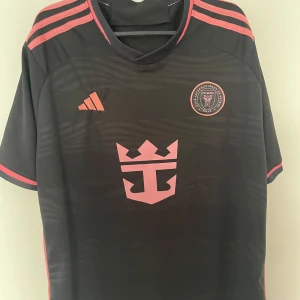 Inter Miami svart fotbollströja Adidas - Rosa Svart Inter Miami fotbollströja . Storlek L kan passa M