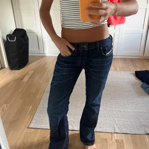 Diesel Jeans  - Säljer ett par mörkblå Diesel jeans med bootcut passform och låg midja. Storlek 30🤍