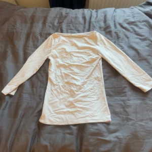 Vit långärmad topp med båtringning - En vit kvarts ärm tröja. Modellen är rak och passar perfekt till jeans eller kjol. Lappen är tyvärr av men den är troligen från Hm. Säljer pågrund av att storleken är för liten