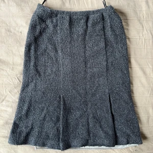 Grå stickad långkjol - Höstens kjol är här! En grå stickad långkjol med mjuk känsla och diskret ribbad struktur. Den har en enkel, rak passform och är fodrad på insidan för kyligare dagar. Så spännande plagg att styla!