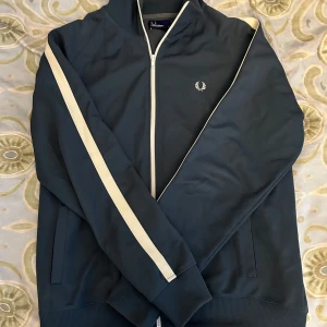 blå Helzip  - Säljer denna blåa helzip från fredperry i storlek L