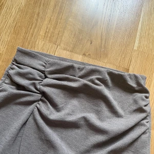 Kortkjol som glittrar  - Snygg grå kortkjol från Kappahl i omlottmodell med draperad detalj i sidan. Köpte denna för en nyårs outfit men blev andra planer!