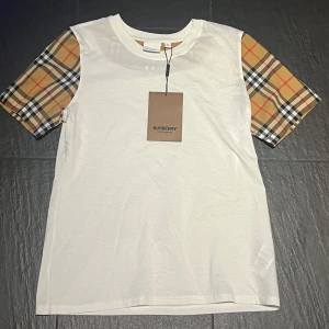 Burberry T-shirt - Snygg vit t-shirt från Burberry. Perfekt för dig som vill sticka ut med en ikonisk detalj från Burberry och bli en snygging. 