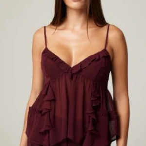 Vinröd volangig topp - Supersöt vinröd topp med tunna axelband och v-ringning. Toppen har flera lager volanger och är gjord i ett lätt, transparent tyg som ger en luftig känsla. Perfekt festtopp. Storlek M, använd en gång. Skriv för mer info eller bilder! 💕