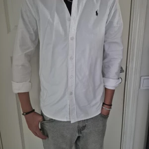 Vit skjorta från Ralph Lauren S - Vit skjorta från Ralph Lauren i storlek S. Klassisk design med knappar framtill och långärmade ärmar. Broderade Polo-loggan på bröstet och är gjord i mjuk bomull.