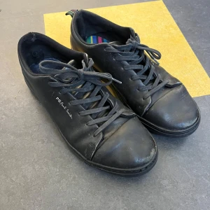 Svarta sneakers från Paul Smith - Svarta sneakers i skinn från Paul Smith. Perfekta för dig som gillar stilrena och minimalistiska skor med en liten twist. Storlek 41 men passar upp till 42,5.    Nypris 2500kr