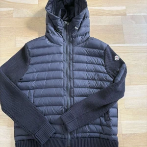 Svart Moncler Cardigan - Snygg svart cardigan från Moncler. Storlek XL men passar perfekt till både storlek M/L. Cardiganen är i nyskick, pris kan diskuteras vid snabbt köp!