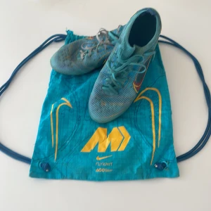 Nike Mercurial blå fotbollsskor - Snygga blå Nike Mercurial fotbollsskor med gula och röda detaljer samt stora Swoosh-loggor på sidorna. Bra skick sitter perfekt. Pris kan diskuteras vid snabb affär 