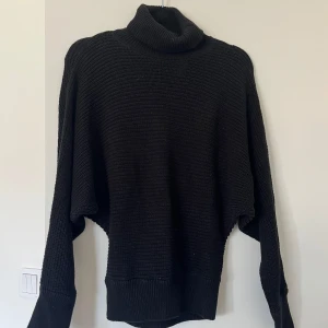 Svart stickad polotröja - Svart stickad polotröja med långa ärmar.