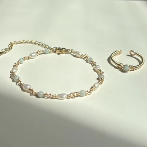 Amazonite Set - Setet innehåller: ✓ Ett handgjort armband ✓ En justerbar ring  Armband: Längd: 16,5 cm + 6,5 cm förlängningskedja Material: Rostfritt stål, äkta sötvattenspärlor och Amazonite (ädelsten)  Ring: Justerbar storlek Material: Rostfritt stål med äkta Amazonite (ädelsten)