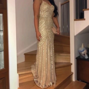 Champagnefärgad långklänning med paljetter - Säljer en elegant långklänning i champagnefärg med glittriga paljetter. Perfekt för bal eller fest. Supersnygg och unik look!   Använd några gånger och någon tecken på användning finns Storlek Xs/34 Pris nu 450kr!!! Fynda!!! Nypris 3500kr