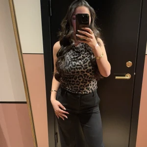 Leopardmönstrad halterneck topp - Säljer en snygg leopardmönstrad halterneck topp med öppen rygg. Toppen är ärmlös och har en tight passform. materialet känns mjukt och följsamt. Perfekt för dig som vill sticka ut med ett djurmönster.