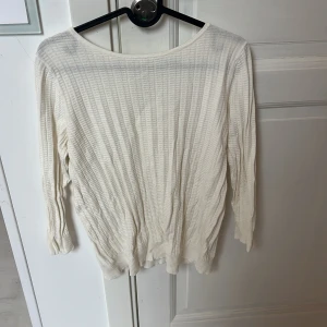 Vit ribbad tröja från Stockh LM - Säljer en vit ribbad tröja från Stockh LM i storlek M. Tröjan har lång ärm, rund halsringning och är tillverkad i ett mjukt, lätt material som passar perfekt till lager-på-lager. Enkel och stilren design som funkar till många outfits.