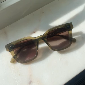 Olivgröna solglasögon från chimi - Snygga solglasögon med transparent grön båge och fyrkantig form. Glasen är bruna med lätt toning. Priset är inte fast så kom med förslag 