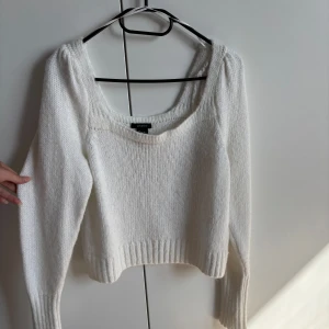 Vit stickad tröja från Lindex - Superfin vit stickad tröja från Lindex med bred, rundad halsringning och långa ärmar. Tröjan har en lite croppad passform och ribbade muddar vid ärmslut och nederkant. Axlarna är puffiga och ärmslutet vid mudden är tajt. Den är helt ny och oanvänd utan prislapp kvar.