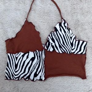 Brun och zebramönstrad linnetopp - Unik linnetopp med patchwork-design i brun och svartvit zebramönstrad bomull. Toppen har vågiga kanter, smala axelband och cool asymmetrisk form. Perfekt för dig som vill sticka ut med en edgy och trendig look.