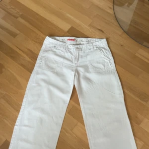 Vita linnebyxor med raka ben - Sjukt snygga vita linnebyxor med raka ben och klassiska fickor både fram och bak. Perfekta för en fräsch och avslappnad look. Lätta och luftiga, passar perfekt till varmare dagar. Köpta på en marknad.