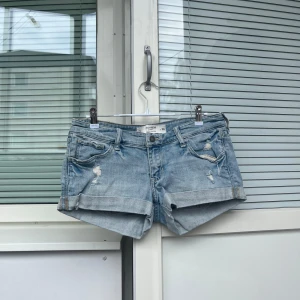 Lowrise Jeansshorts - Lågmidjade jeansshorts i mycket skick utan defekter, slitningarna är en del av designen💓 38,5cm rakt över midjan, 17,5cm grenhöjd och 24cm långa mätt på sidan!💓