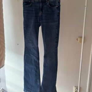 Blå bootcut jeans från Gina Tricot - Snygga blå jeans från Gina Tricot i modellen Perfect Jeans. Klassisk femficksdesign, bootcut-ben och låg midja. Jeansen är i ett mjukt denimtyg med lite stretch och har snygga kontrastsömmar. Perfekta för dig som gillar en tidlös look.