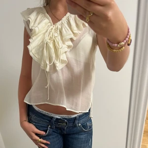 Vit blus med volang från Zara  - Supersöt vit blus från Zara. Köpt förra våren så säljs förmodligen inte mer. Perfekt ny till sommaren!  