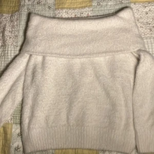 Vit fluffig Off Shoulder tröja från H&M vintage - . Supermjuk och fluffig vit Off Shoulder tröja från H&M Tröjan är mysig varm å tung att götta sig me. Materialet känns mysigt och ger en stilren look. Jag köpte den i en second handbutik. Knappt andvänd av mig.
