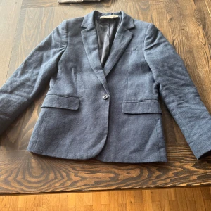 Blå kavaj från h&m - Säljer denna blåa kostymen från h&m. Den är storlek 140/9-10år. Den har bara kommit till användning 2gngr. Inga fläckar eller slitage. Skriv till mig om ni har några frågor!