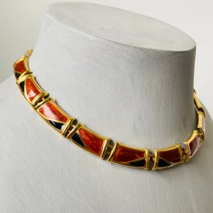Vintage halsband med geometriska former - Unikt halsband med geometriska länkar i guldton, dekorerade med röd och svart emalj. Halsbandet har en chunky design och känns retroinspirerat, perfekt för dig som gillar statement-smycken.