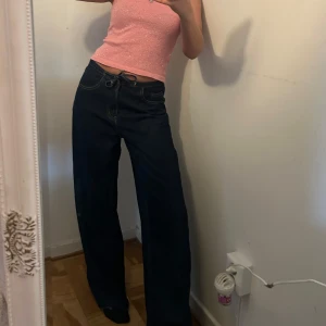 Mörkblå wide jeans med snörning - Säljer ett par mörkblå jeans med breda ben och snörning i midjan. De är lågmidjade. Perfekta för en avslappnad och trendig look. OBS (endast testade aldrig använda) 