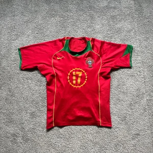Fotbollströja Portugal 2004 - Tja, säljer denna sällsynta Portugal tröja ända från 2004. Tröjan har det ikoniska C.Ronaldo nr17 på ryggen. Tröjan är synligt använd men har inga större defekter. Frågor? Hör av dig! Pris diskutabelt👍
