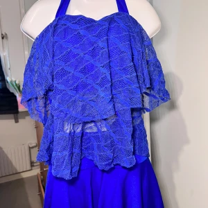 Set Blå bikini med spetsdetaljer 2 delar - Snygg blå bikini med volang och spetsdetaljer. Toppen har knytband och en vacker spetsdesign, medan underdelen har short under