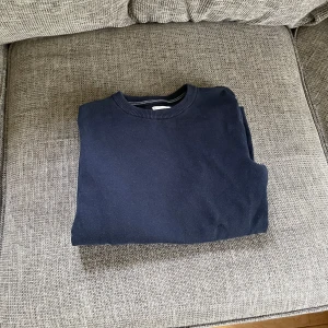 Mörkblå tröja från MNG - Säljer en stilren mörkblå tröja från MNG. Tröjan är i perfekt skick och har inga defekter. Den är perfekt inför sommaren eftersom den är ganska tunn och den är enkel att matcha med andra plagg!